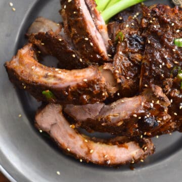 A pewter plate holding some Easy Oven-baked Asian Baby Back Ribs.