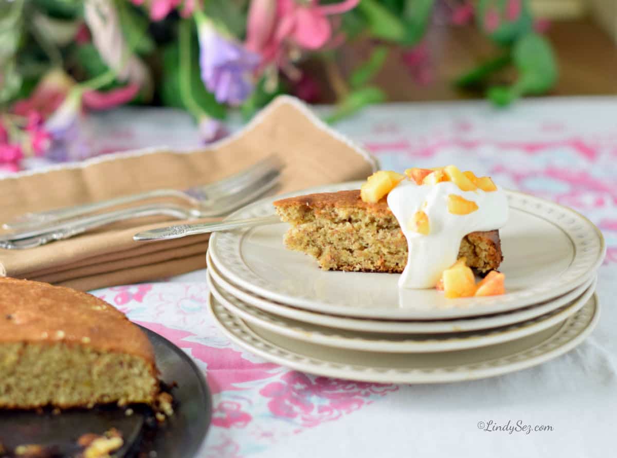 A slice of peach almond torte onwhite plates.