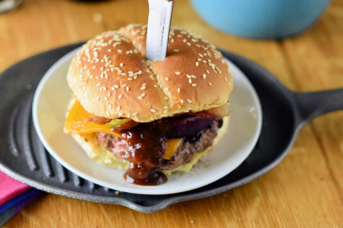 Chipotle BBQ sauce runs down the front of a coffee-crusted cheeseburger.