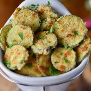 A white holder filled with crispy zucchini crisps.