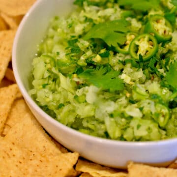 Corn tortilla chips spread around some Garden Fresh Green Tomato Salsa.