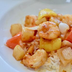 Pineapple and peppers mix with shrimp and sauce to make Easy Homemade Spicy Sweet and Sour Shrimp.