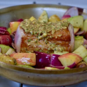 Roasted Pork Loin with Apples and Onions cooking in a pan.