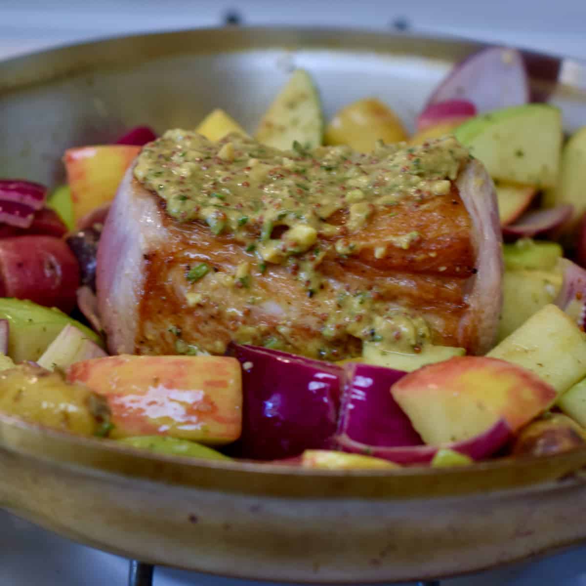 Roasted Pork Loin with Apples and Onions cooking in a pan.
