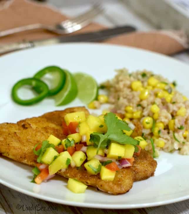 Plated simple panfried curry snapper with mango salsa along with brown rice and corn saute