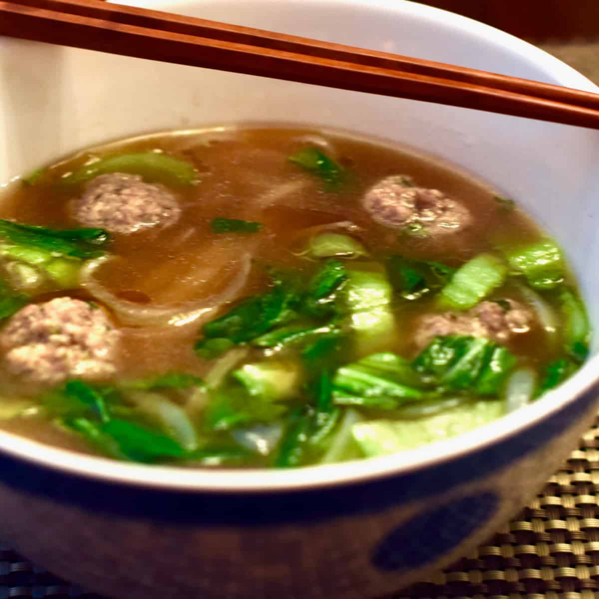 A bowl of Quick Pho with Ginger Pork Meatballs with chopsticks.