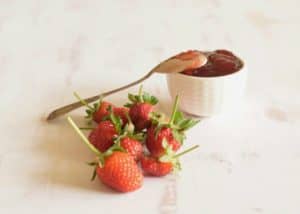 Easy Fresh Strawberry Jam with Balsamic header shot with white bowl and spoon.