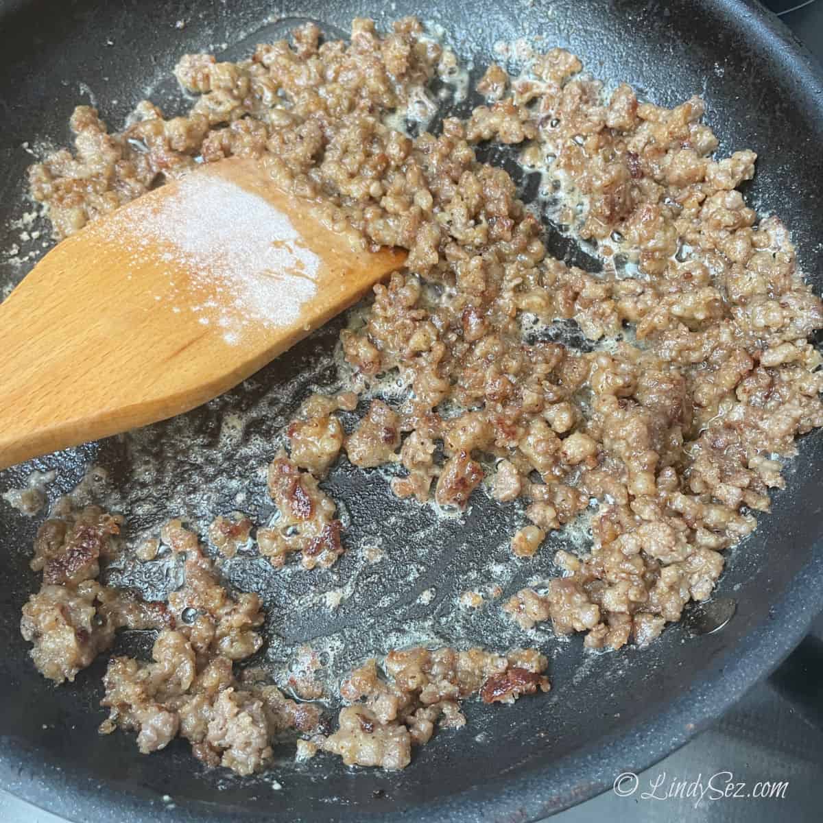 Stirring flour into sausage.