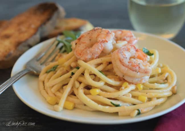 A beautiful plate of pasta with shrimp and pine nuts.