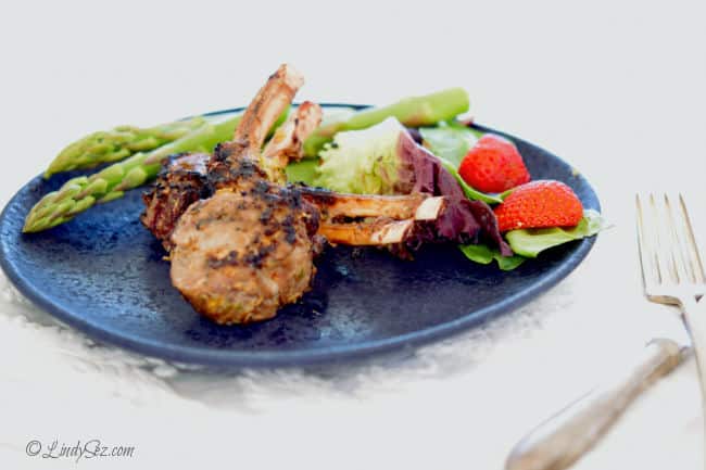 Grilled Lemongrass Lamb Chops on a blue plate with a green salad and fresh asparagus. 