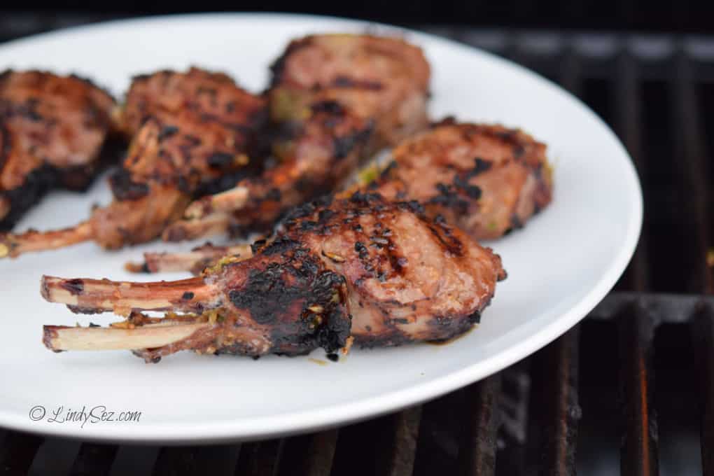 A white plate with perfectly grilled Slanted Doors Grilled Lamb Chops on it. 
