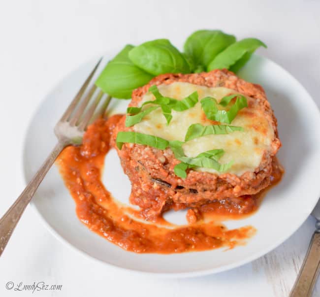 A white plate with a serving of Easy low-fat baked eggplant parmesan on it.