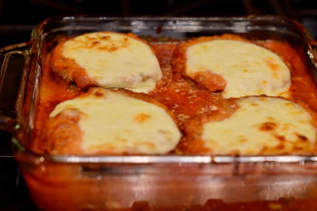 Eggplant parmesan in a pan with a topping of nicely melted browned mozzarella cheese.