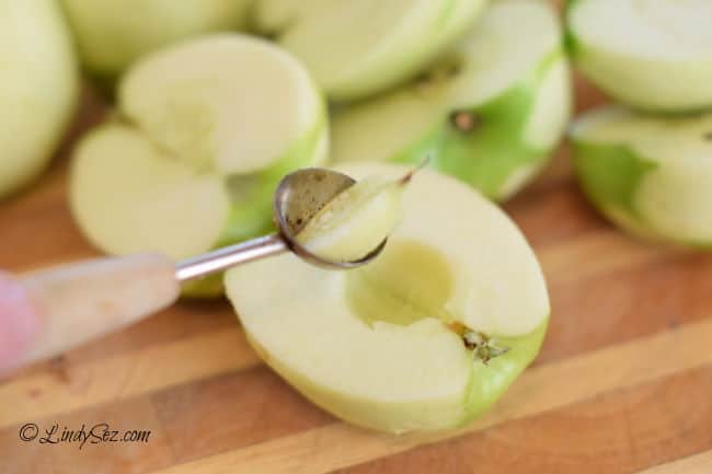 Using a melon baller to remove the core of an apple.