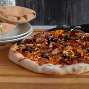 A beautiful pizza on a cutting board.