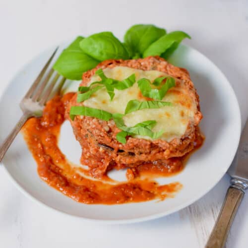 Platted eggplant parm with basil garnish.