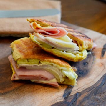 A Cuban sandwich cut in half showing all of its layers.