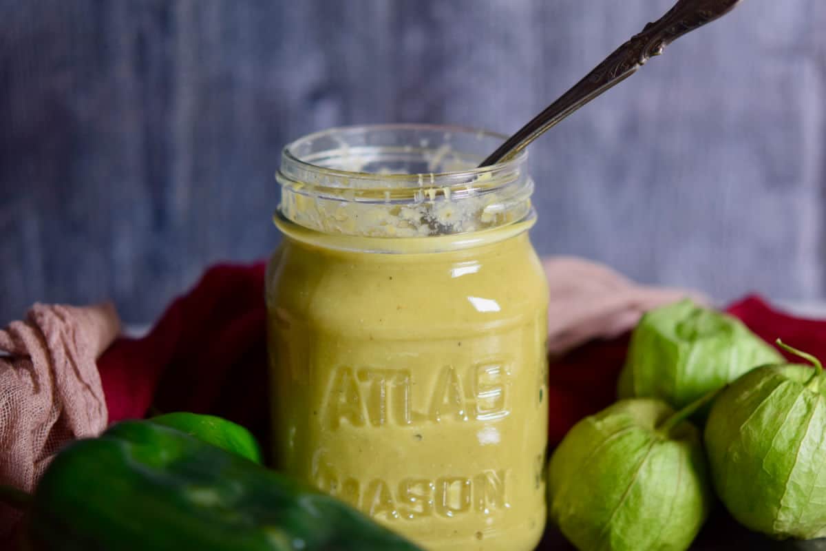 A jar of green enchilada sauce with tomatillos.