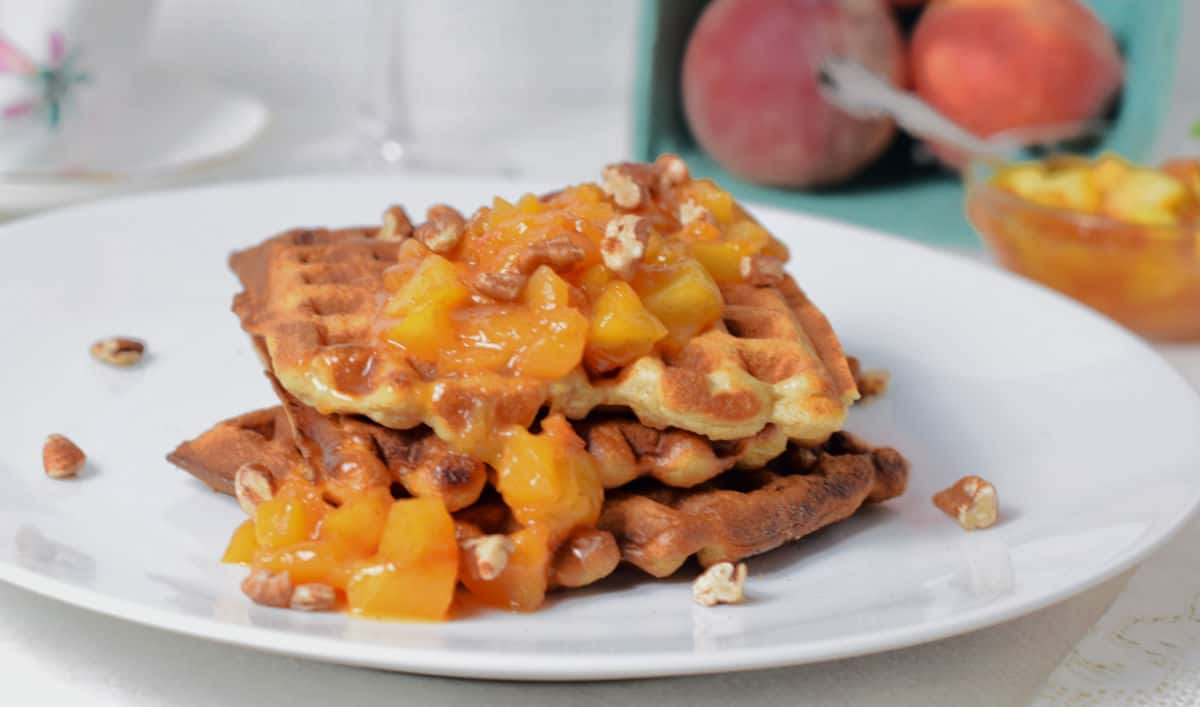 Peach Pecan Waffles with fresh peach compote on top.