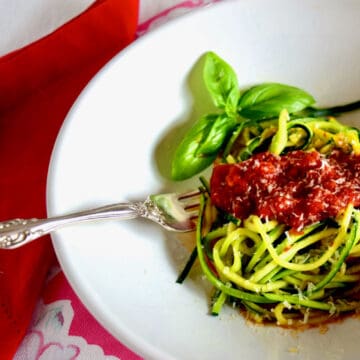 A half bowl of zucchini spaghetti with sauce.