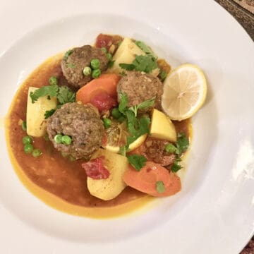 A white bowl of Spicy kefta with vegetables.